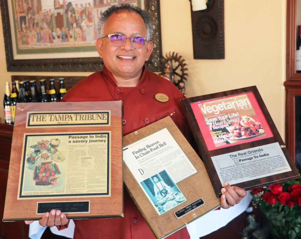 Chef holding awards given to Guru Indian Restaurant